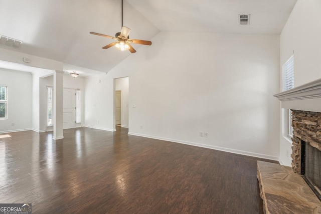 unfurnished living room with a stone fireplace, dark wood-type flooring, visible vents, and a ceiling fan