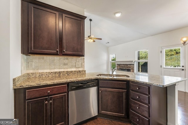 kitchen with light stone counters, lofted ceiling, a peninsula, and stainless steel dishwasher