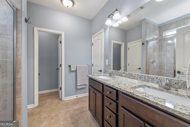 full bath featuring double vanity, a shower stall, baseboards, and a sink