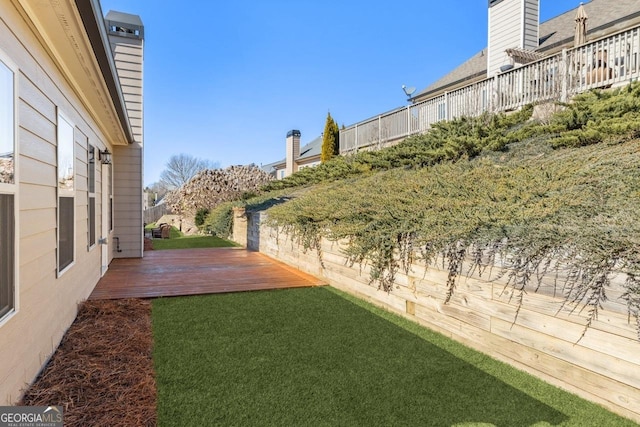 view of yard featuring fence and a wooden deck