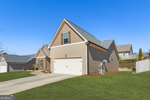 traditional-style home with a garage, fence, concrete driveway, and a front yard