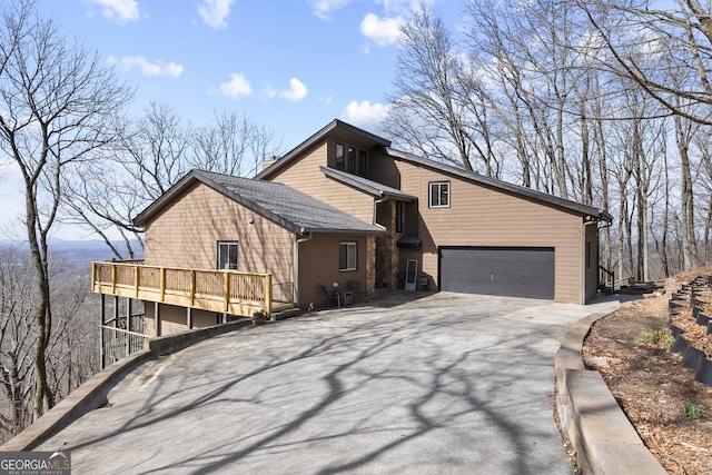 view of side of home featuring a garage and aphalt driveway