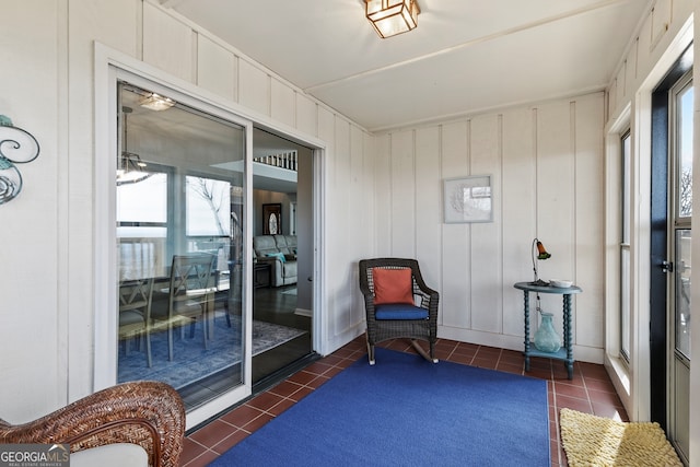 sitting room with a sunroom, plenty of natural light, and dark tile patterned floors