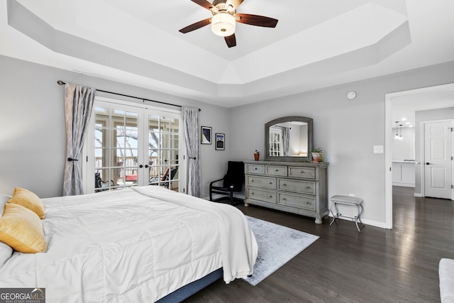 bedroom featuring access to exterior, french doors, a raised ceiling, dark wood-type flooring, and baseboards