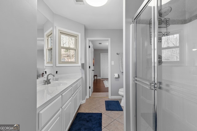 bathroom with visible vents, toilet, vanity, a shower stall, and tile patterned floors