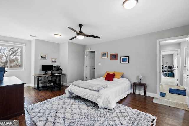 bedroom featuring a ceiling fan, visible vents, baseboards, and dark wood-type flooring