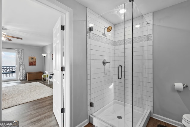 bathroom with a shower stall, baseboards, and wood finished floors