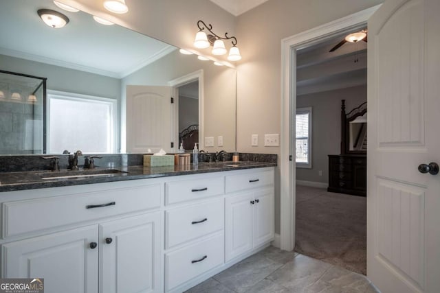 full bathroom featuring baseboards, double vanity, a sink, and crown molding