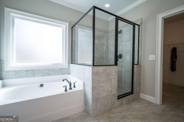 bathroom with a walk in closet, ornamental molding, a stall shower, baseboards, and a bath