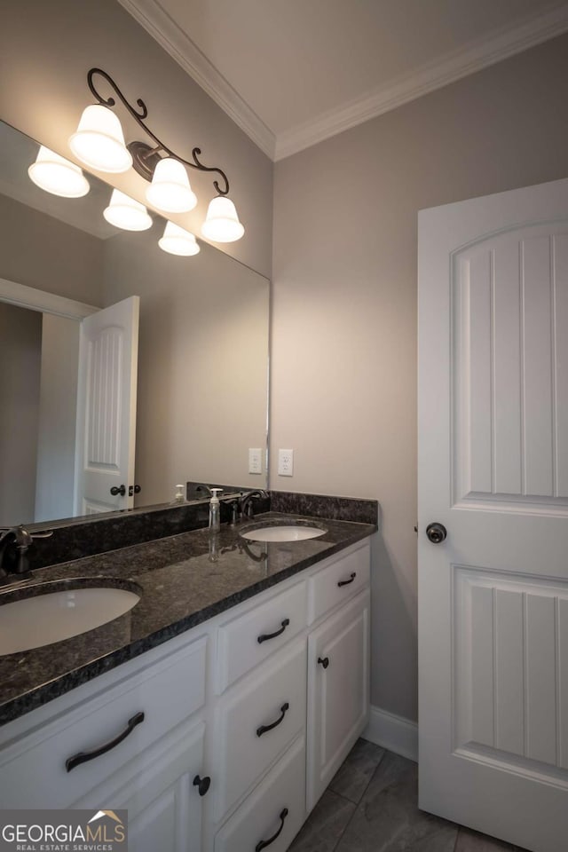 full bath with double vanity, baseboards, ornamental molding, and a sink