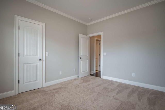 unfurnished bedroom featuring baseboards, carpet floors, and crown molding