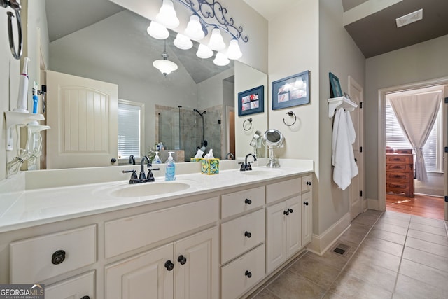 full bathroom featuring double vanity, visible vents, a sink, a shower stall, and tile patterned floors