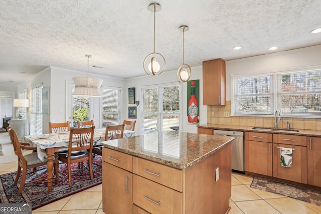 kitchen featuring dark stone counters, a sink, backsplash, dishwasher, and decorative light fixtures