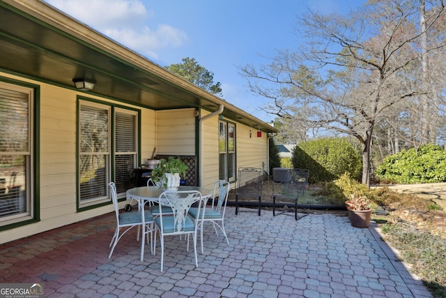 view of patio featuring outdoor dining area and central AC unit