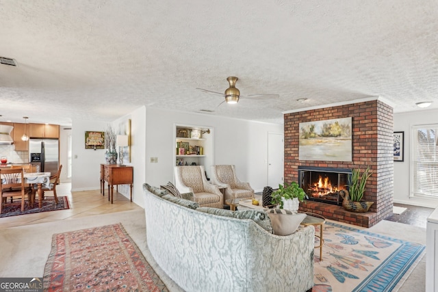 living room with built in shelves, a brick fireplace, light tile patterned flooring, and a textured ceiling