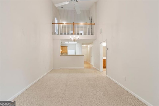 interior space with baseboards, a towering ceiling, and a chandelier