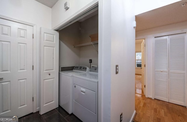 laundry area with dark wood-type flooring, laundry area, and independent washer and dryer