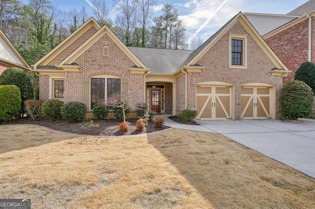 view of front of property with a garage, a front yard, concrete driveway, and brick siding