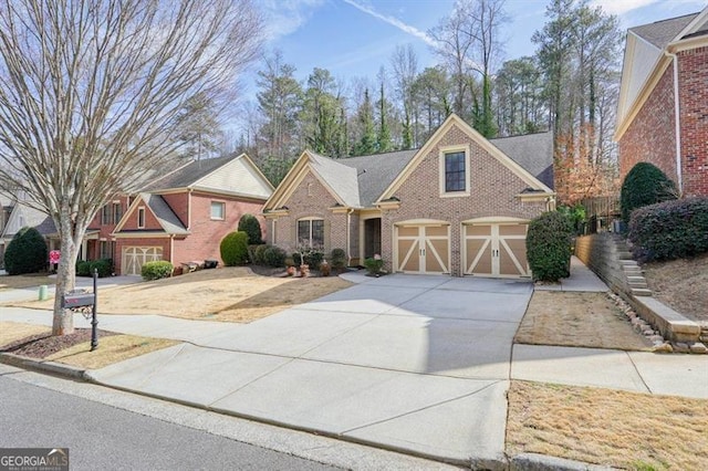 traditional-style home featuring a garage, concrete driveway, and brick siding