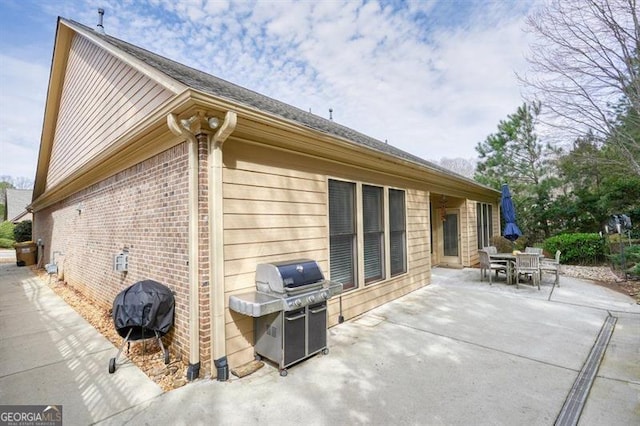 view of side of property with a patio and brick siding