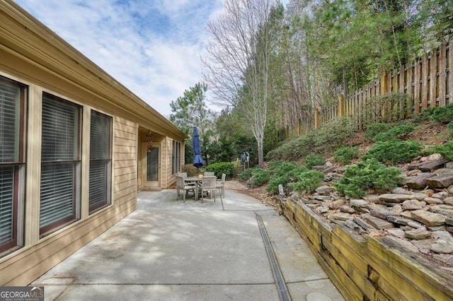 view of patio with outdoor dining space and fence