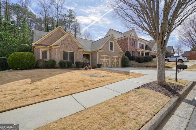 view of front of house with driveway, a garage, a front lawn, and brick siding