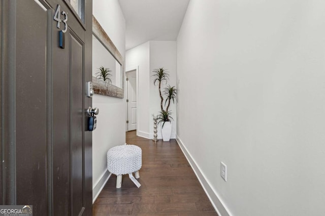 interior space featuring dark wood-type flooring and baseboards