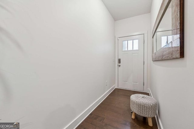 doorway featuring dark wood-style floors and baseboards