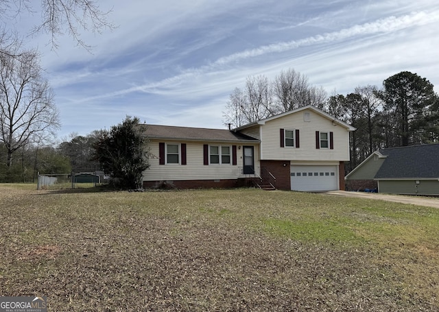 tri-level home with a garage, driveway, and a front lawn