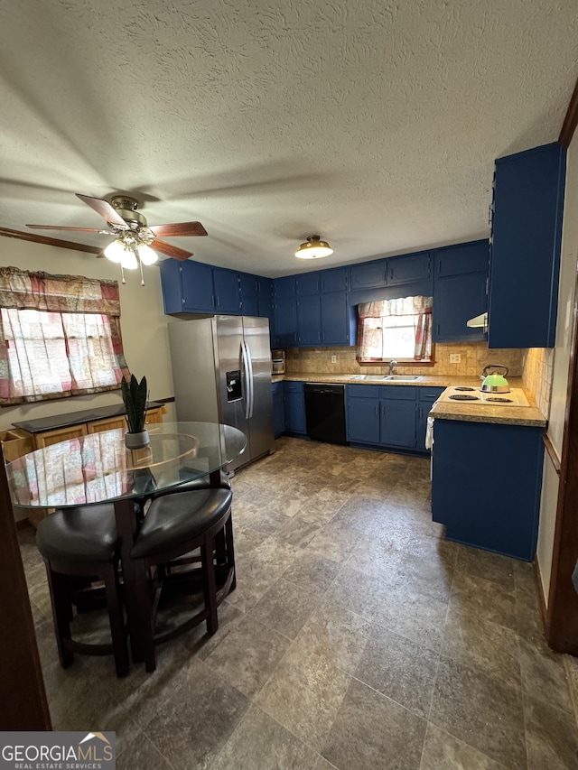 kitchen featuring a sink, light countertops, blue cabinetry, stainless steel refrigerator with ice dispenser, and dishwasher