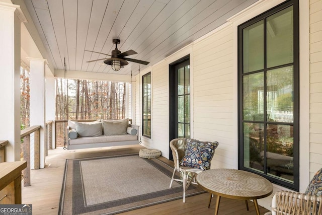 sunroom with ceiling fan, plenty of natural light, and wooden ceiling