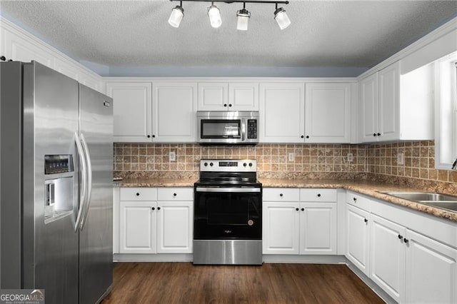 kitchen with tasteful backsplash, dark wood-style floors, appliances with stainless steel finishes, white cabinetry, and a sink