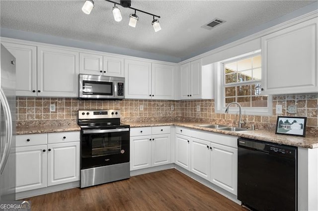 kitchen featuring dark wood-style flooring, stainless steel appliances, visible vents, white cabinetry, and a sink