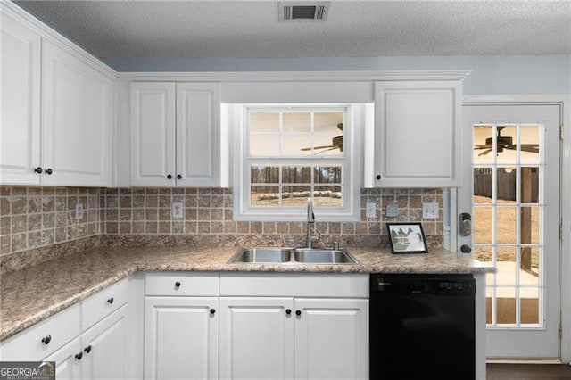 kitchen featuring a sink, visible vents, white cabinetry, black dishwasher, and backsplash