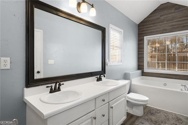 bathroom with lofted ceiling, double vanity, a sink, and a bath