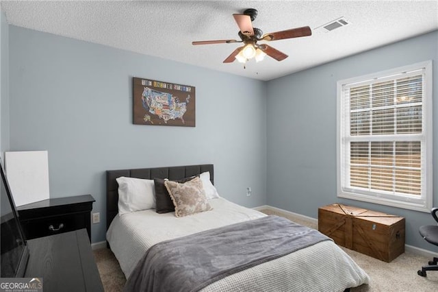 bedroom with light carpet, a textured ceiling, visible vents, and baseboards