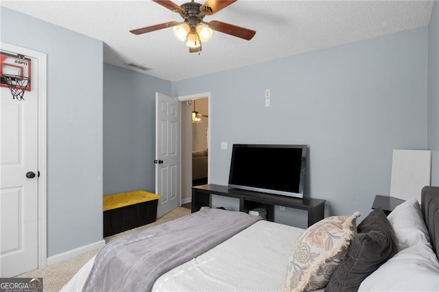 bedroom with ceiling fan, a textured ceiling, light carpet, visible vents, and baseboards