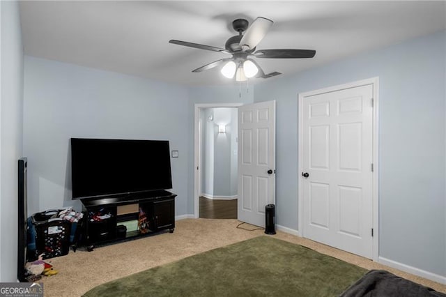 carpeted living room featuring ceiling fan, visible vents, and baseboards