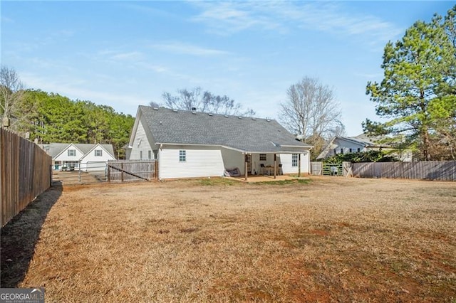 back of property featuring a fenced backyard and a lawn