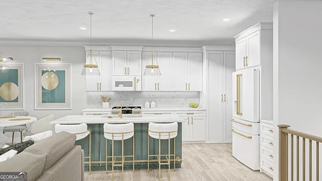 kitchen featuring light countertops, white appliances, hanging light fixtures, and white cabinets