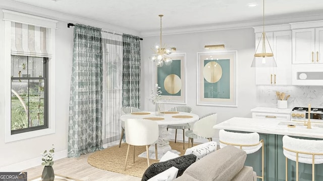 dining area featuring light wood-style flooring, baseboards, a chandelier, and crown molding