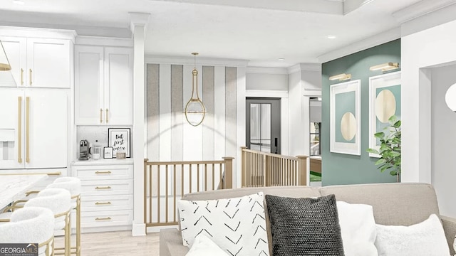 bedroom featuring white built in fridge, light wood-type flooring, and crown molding