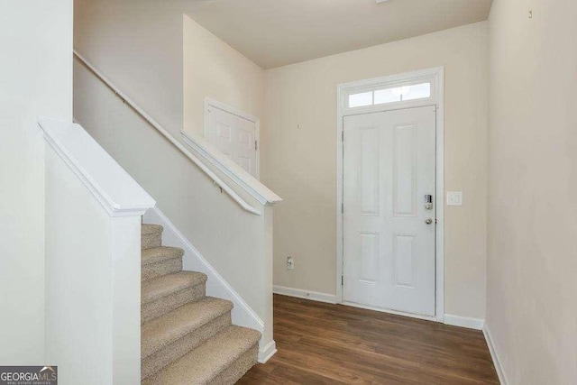 entrance foyer featuring dark wood finished floors, baseboards, and stairs