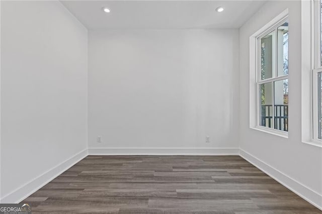 spare room featuring dark wood-style floors, baseboards, and recessed lighting