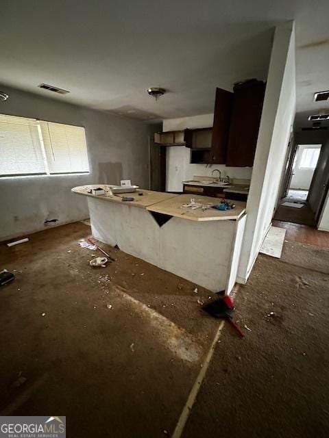 kitchen featuring light countertops, a sink, visible vents, and dark brown cabinets