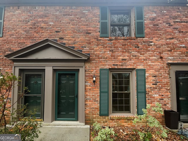 view of exterior entry with brick siding