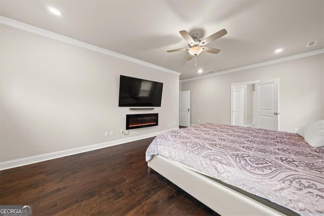 bedroom featuring ornamental molding, dark wood finished floors, a glass covered fireplace, and baseboards