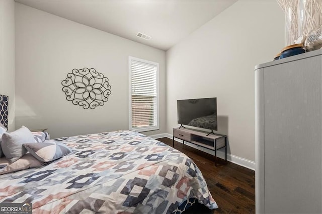 bedroom featuring lofted ceiling, dark wood finished floors, visible vents, and baseboards