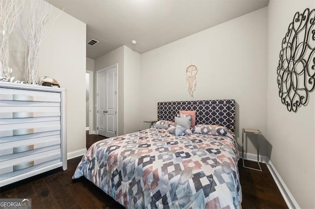 bedroom with dark wood-style flooring, visible vents, and baseboards