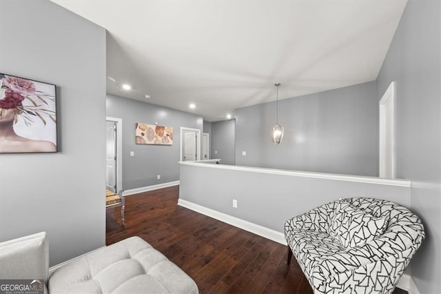 living area featuring baseboards, dark wood finished floors, and recessed lighting